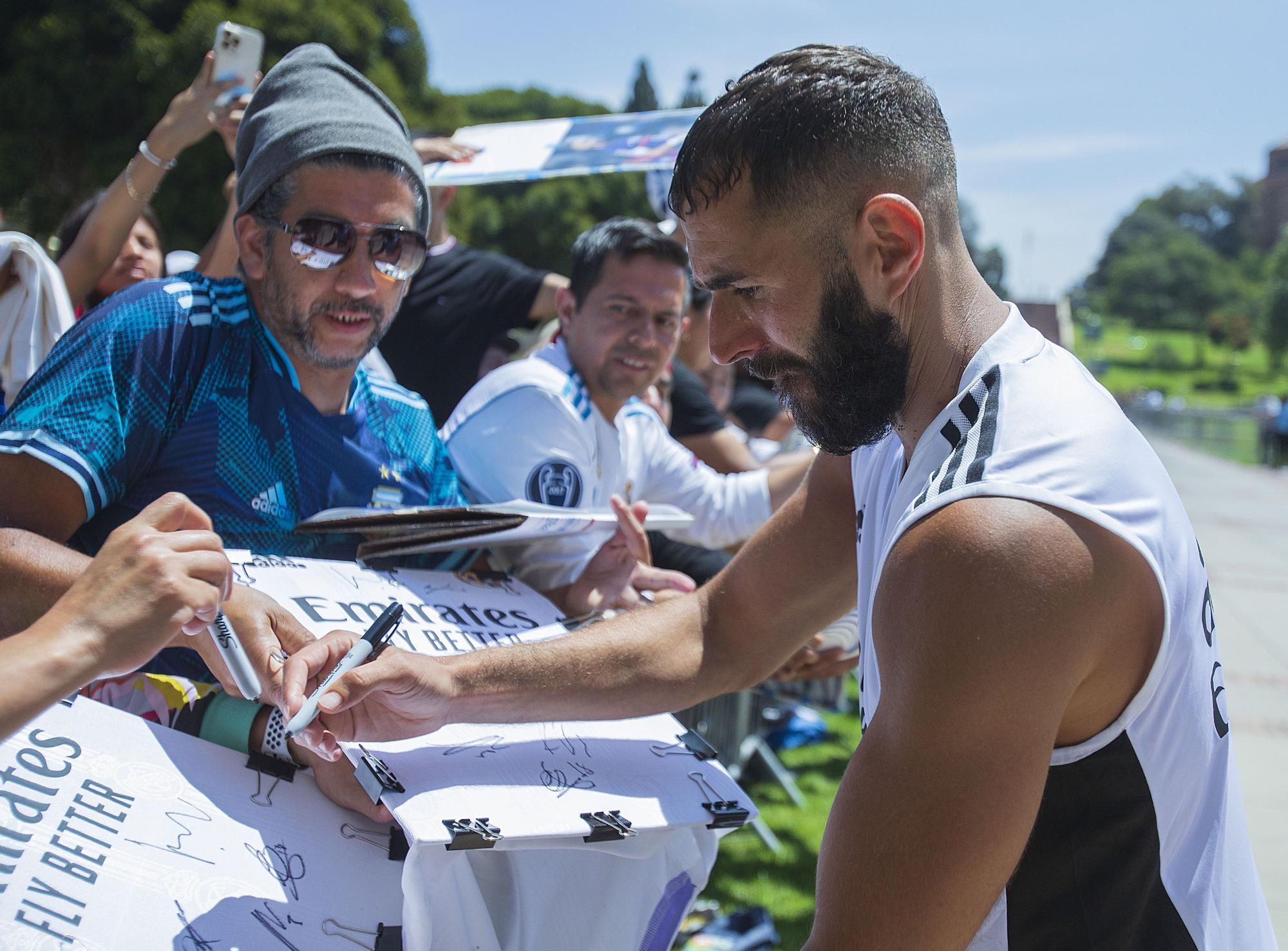 Karim Benzema firma autógrafos a los aficionados durante el último entrenamiento