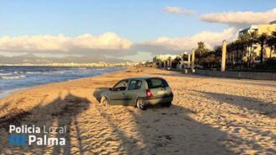 Coche varado en la arena de la Playa de Palma retirado por la grúa municipal.