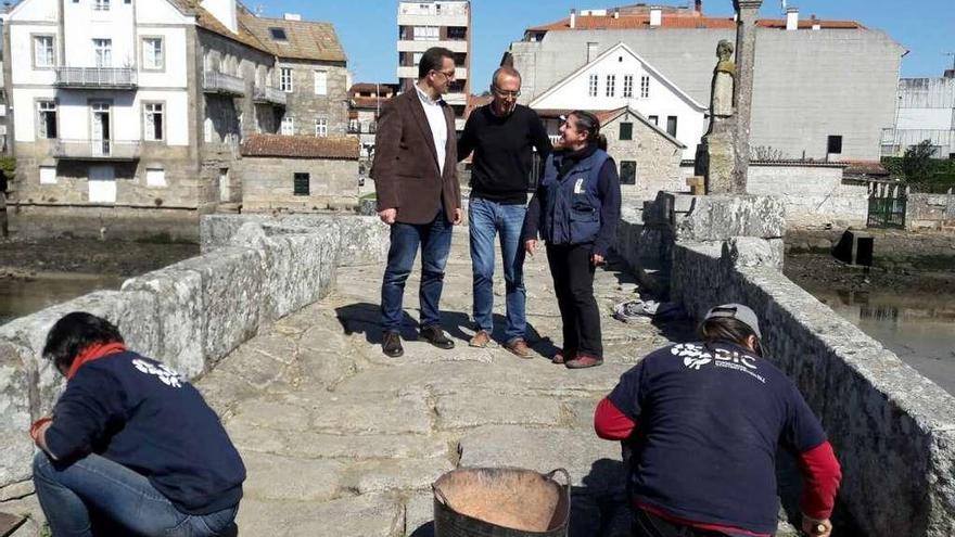 Los alcaldes de los dos municipios, ayer, en el lugar donde se inicia la restauración del cruceiro.  // D.P.