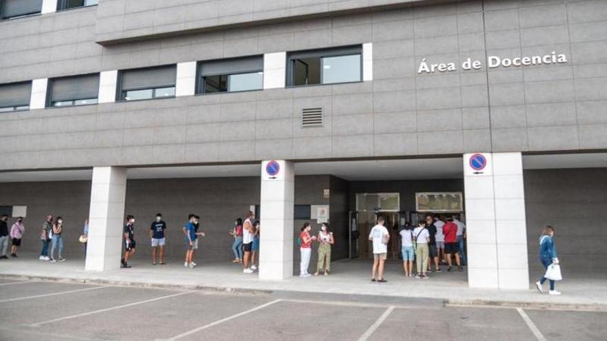 Varias personas forman una cola en la puerta del salón Guadiana del Hospital Universitario de Badajoz.