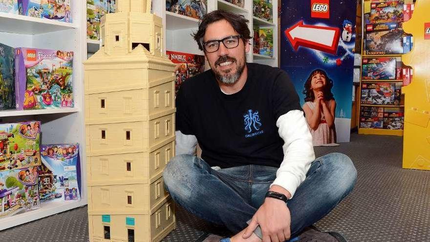 El propietario de Juega Bien, José Manuel López Duarte, posa con la Torre de Hércules de Lego.