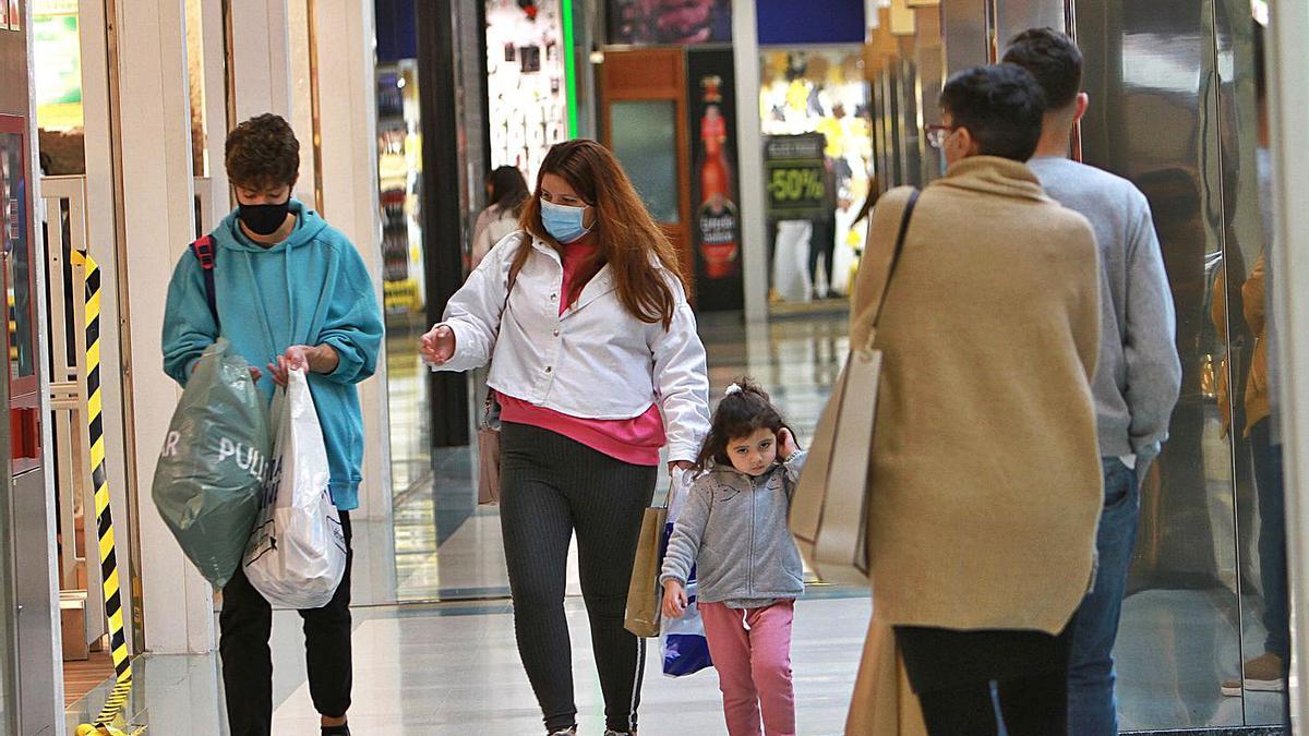 Una famlia en el Centro Comercial PonteVella aprovechando los descuentos en el sector textil.   | // I. OSORIO