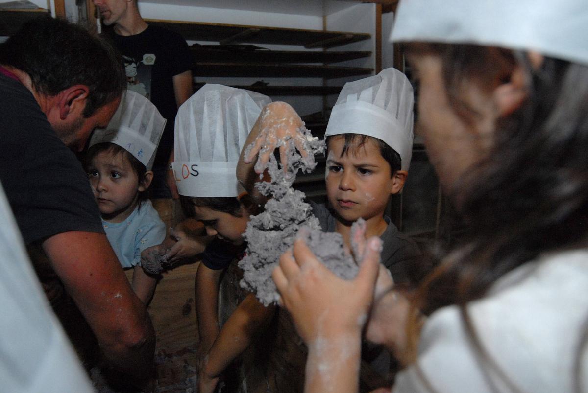 Un grupo de alumnos da escuela prepara a masa para o pan.