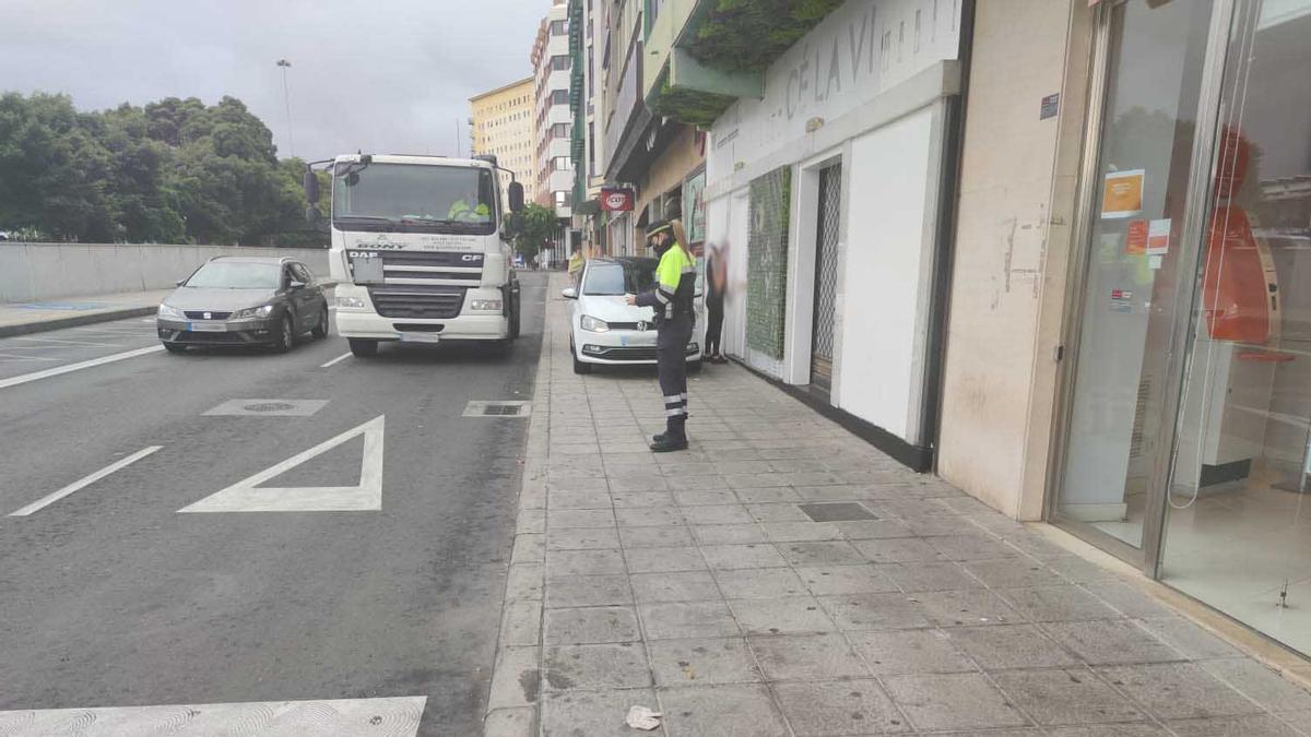 La agente de Movilidad junto al vehículo estacionado sobre la acera en Mesa y López.