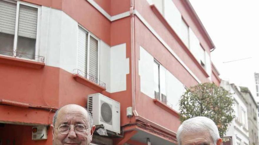 Luis y Gumersindo Bóveda, delante de su casa materna, en Sanjurjo Badía, con el árbol genealógico y un recorte de FARO. // Marta G. Brea
