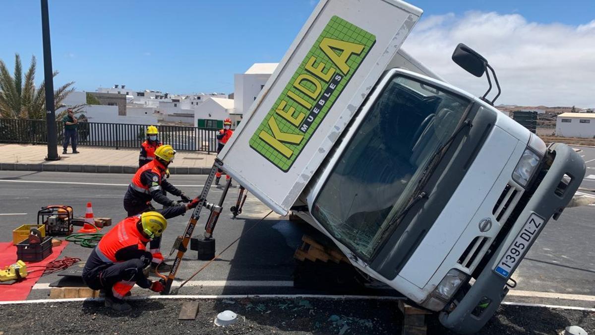 Los bomberos del Consorcio de Seguridad y Emergencias de Lanzarote tratan de poner el camión sobre sus cuatro ruedas.