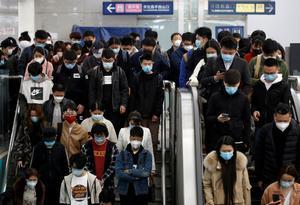 People wearing face masks stand on an escalator inside a subway station during morning rush hour in Beijing, as the spread of the novel coronavirus disease (COVID-19) continues in the country, in China April 7, 2020. REUTERS/Tingshu Wang REFILE - CORRECTING DESCRIPTION OF ESCALATOR