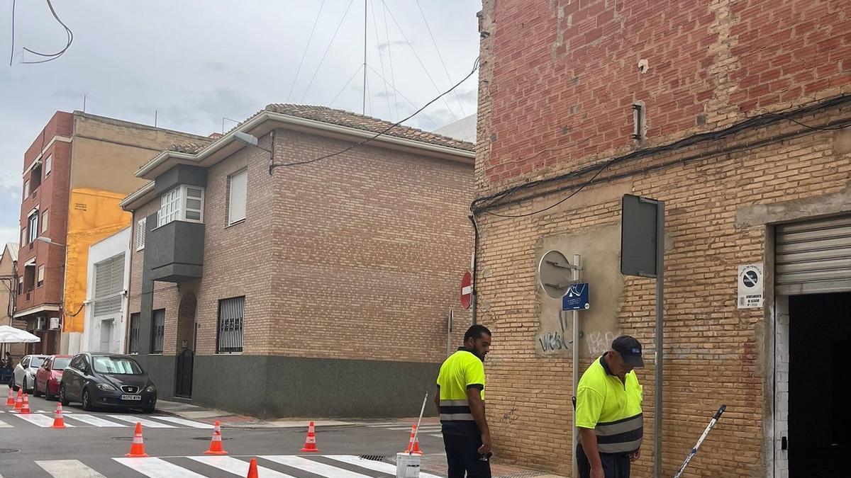 Los operarios pintan un paso de peatones de las rutas escolares.
