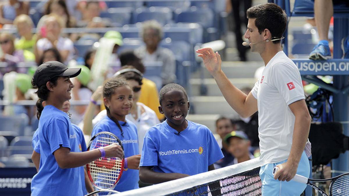 Novak Djokovic saluda a unos niños en la pista Arthur Ashe de Flushing Meadows