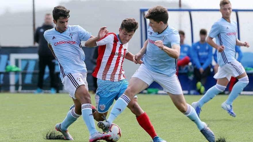 Dos jugadores del Celta tratan de frenar a un rival durante un encuentro en A Madroa. // Marta G. Brea