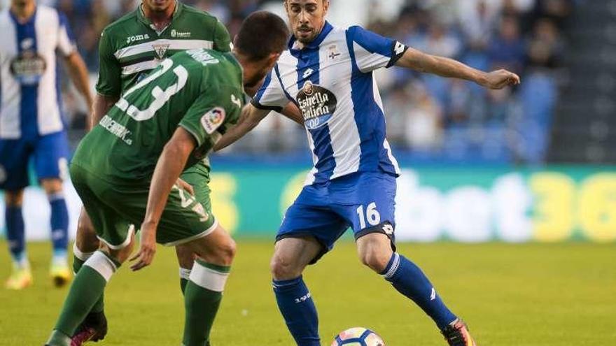 Luisinho intenta eludir a dos rivales durante el partido.