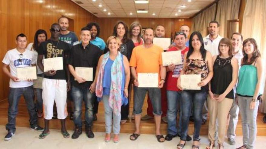 Los inmigrantes posan con sus diplomas junto a la alcaldesa, la directora general, la edil y sus profesores.