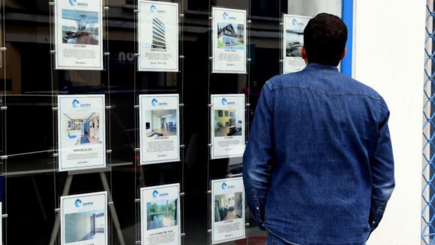 Un hombre mira ofertas de inmuebles en una inmobiliaria. | // VÍCTOR ECHAVE