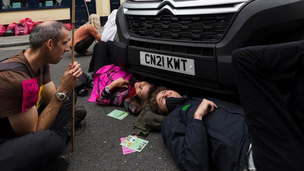 Activistas climáticos cortan el tráfico en Londres encadenándose a un coche.