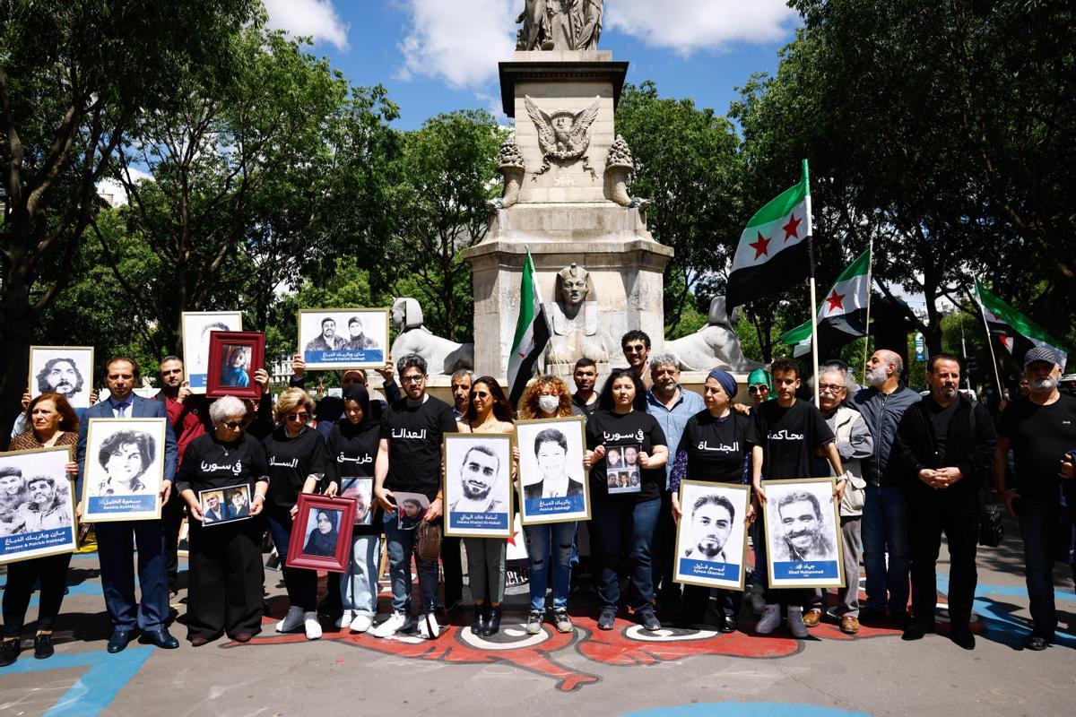 Activistas sirios con carteles de 'La justicia es el camino para la paz&quot; .