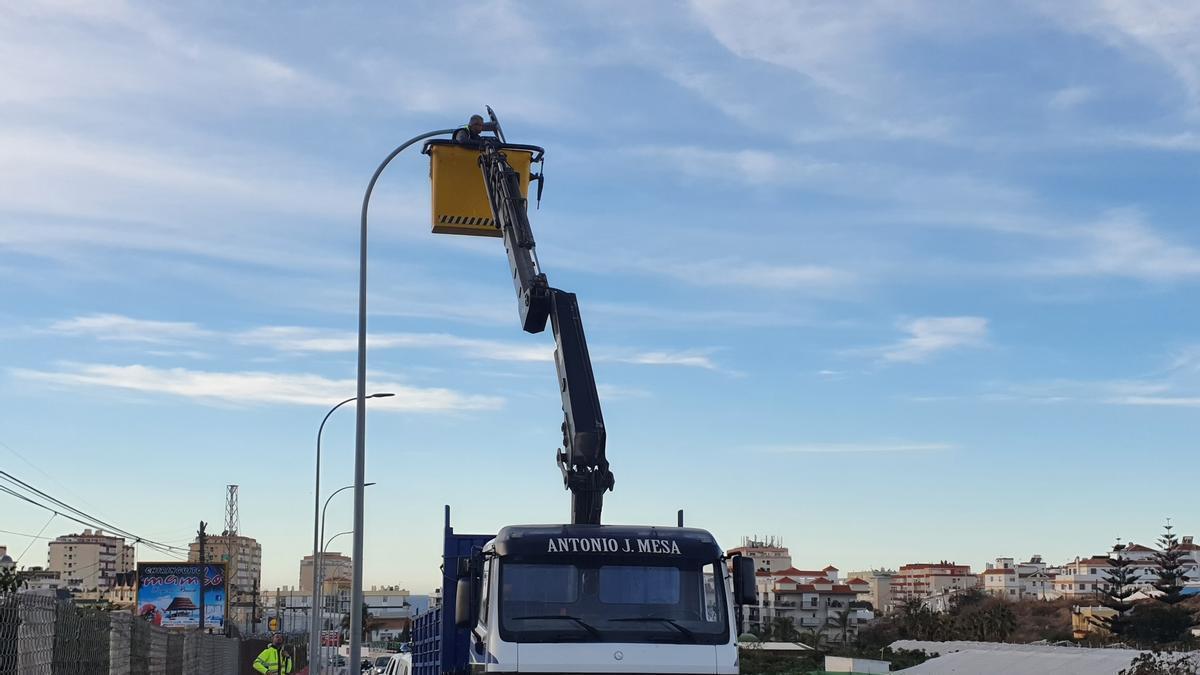 Un operario cambia una de la luminarias.