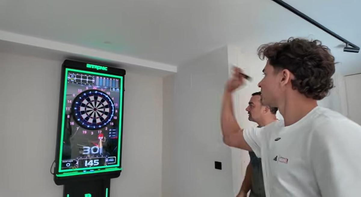 Julián Álvarez juega a los dardos en su sala de juegos.