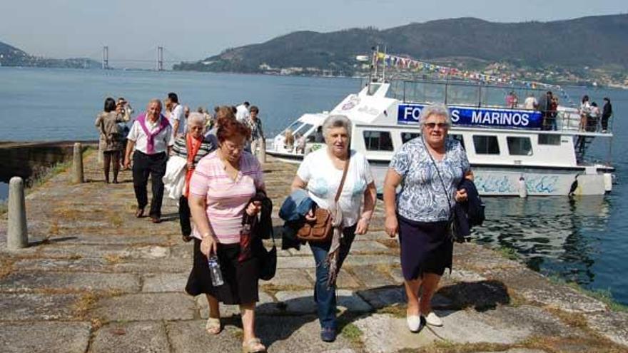 Un grupo de personas accede a la isla de San Simón, ayer, durante el estreno de la línea regular de transporte en barco.  // Faro