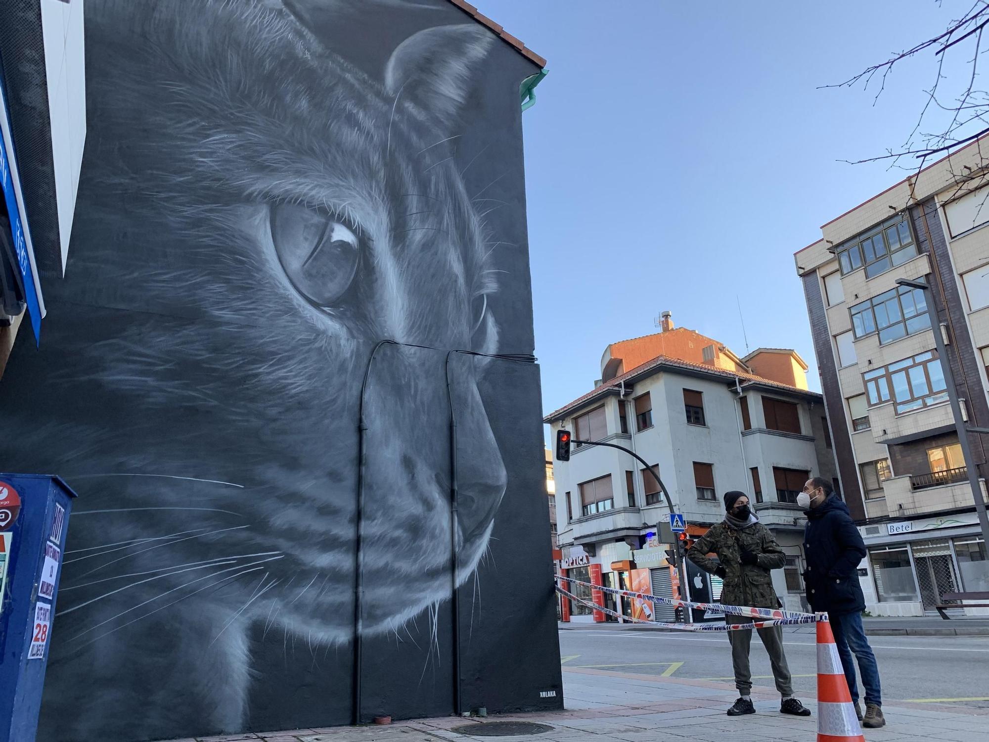 Ángel Caballero, alias &quot;Xolaka&quot;, a la izquierda, con el alcalde de Siero, ante el grafiti en la avenida de Oviedo de Lugones. 