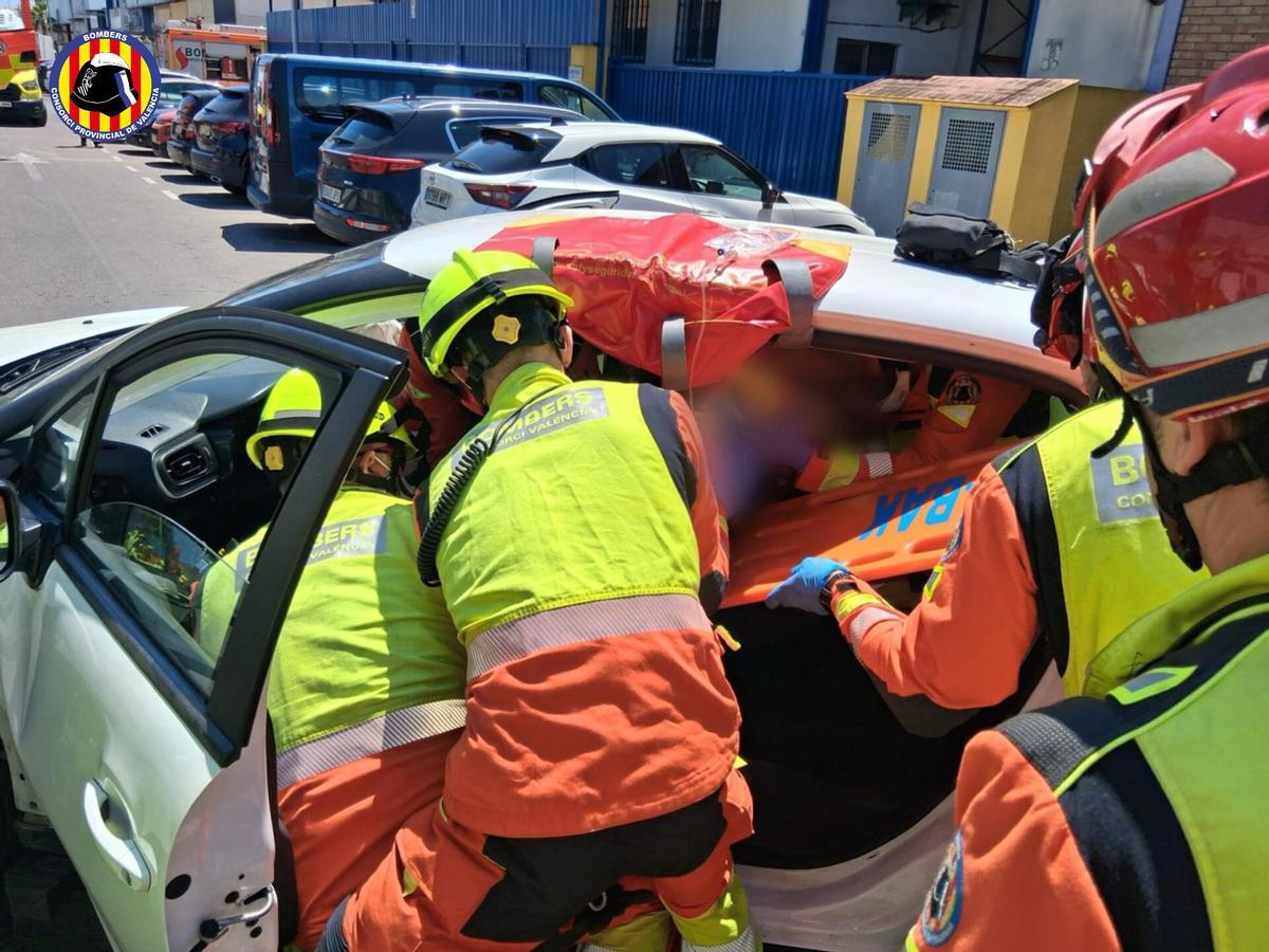 Los bomberos tratando de excarcelar al conductor del turismo.