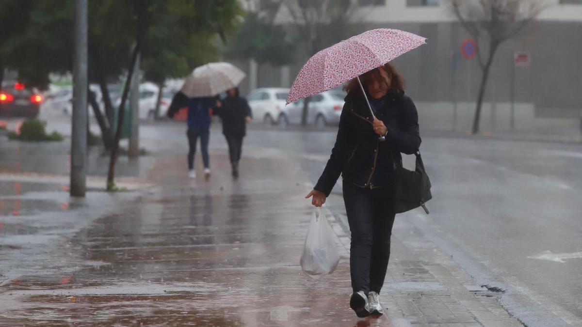 Una mujer se protege de la lluvia en Córdoba.