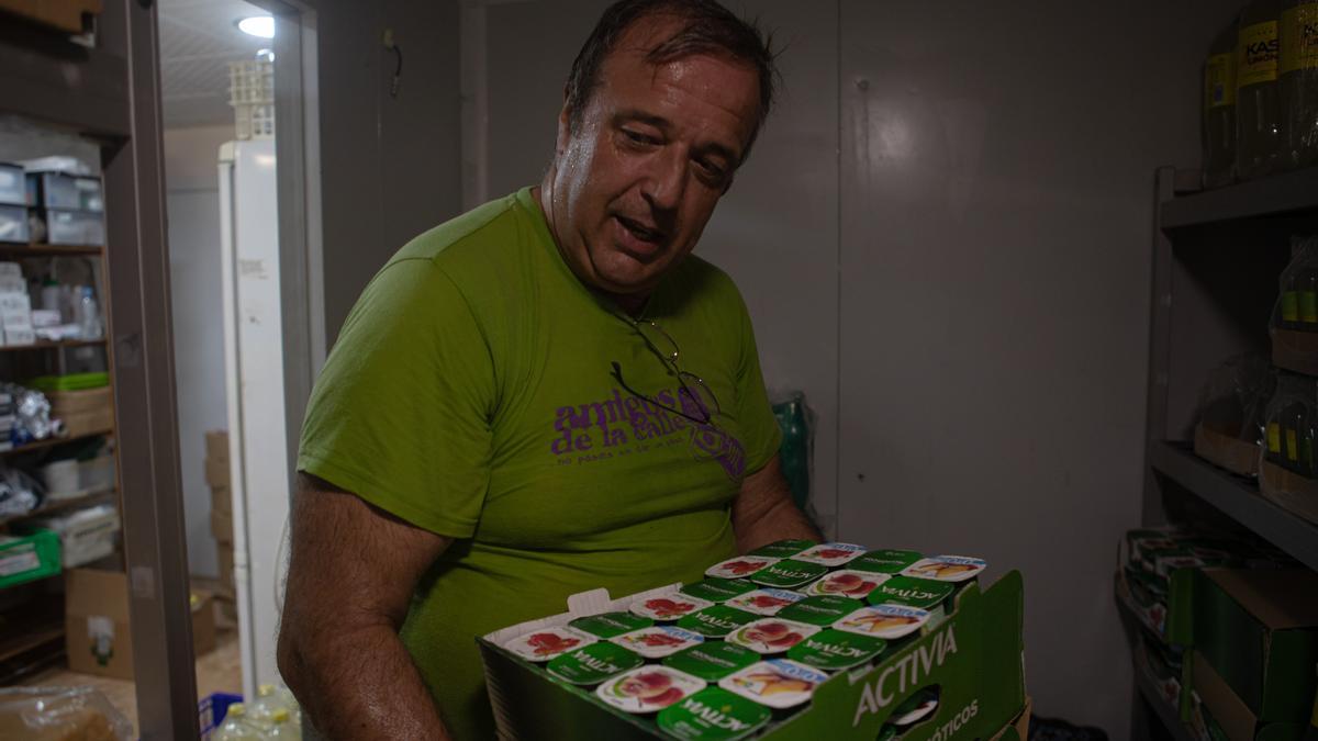 Dean Ibañez entra con una caja de yogures a la nevera de la asociación Amigos de la calle.