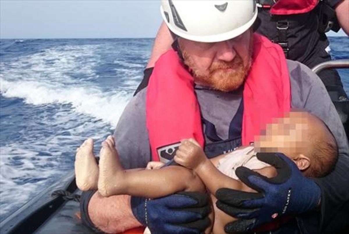 Un voluntario de Sea Watch sujeta el cadáver de un bebé ahogado a finales del pasado mayo tras un naufragio en el Mediterráneo. Un voluntario de Sea Watch sujeta el cadáver de un bebé ahogado a finales del pasado mayo tras un naufragio en el Mediterráneo.