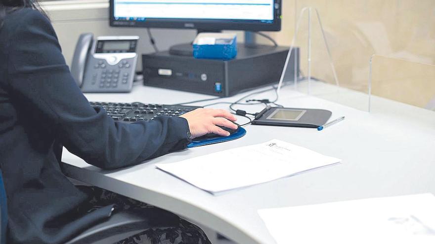 Una empleada pública trabajando con un ordenador.