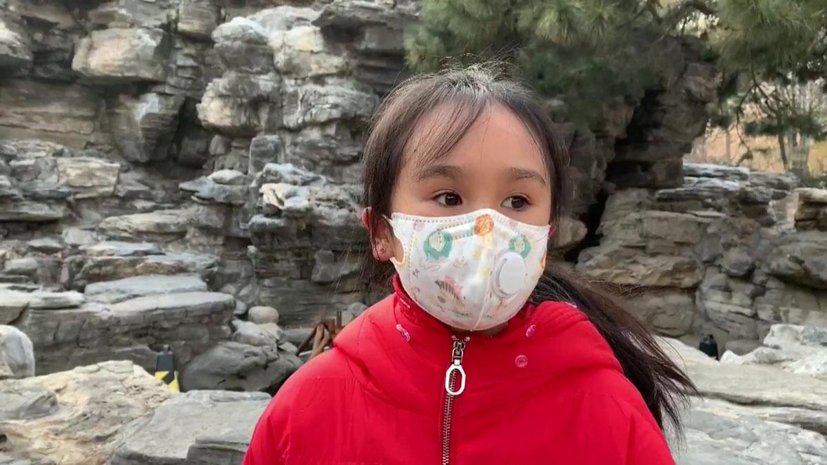 Niña en China con mascarilla para evitar el contagio del coronavirus.