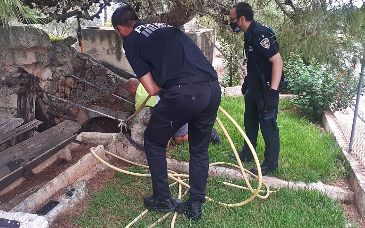 Policías locales de sa Pobla examinan el pozo en el que había caído el hombre. | POLICÍA LOCAL DE SA POBLA