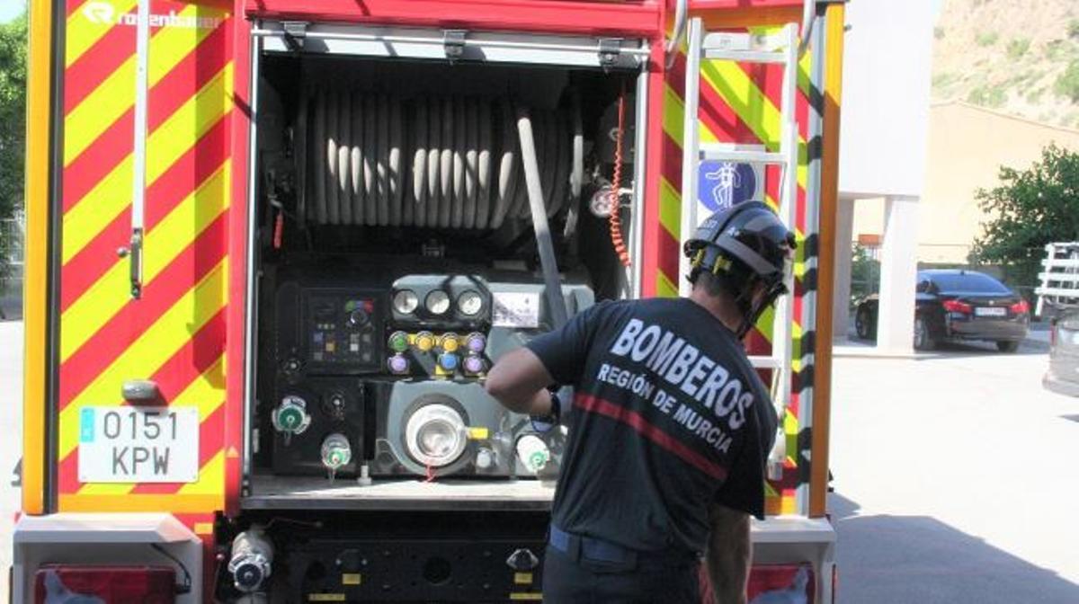 Un efectivo junto a un camión de bomberos.