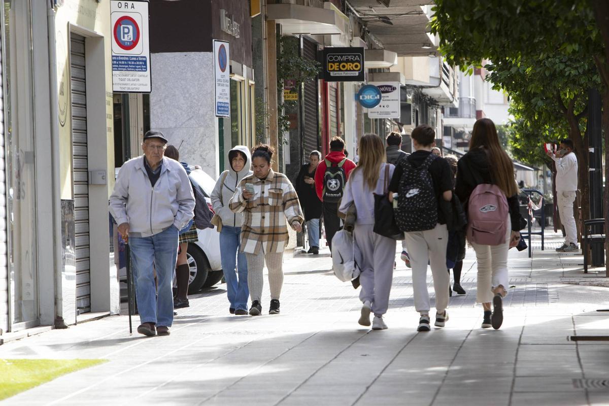 Un grupo de personas pasea por la principal avenida de Alzira.
