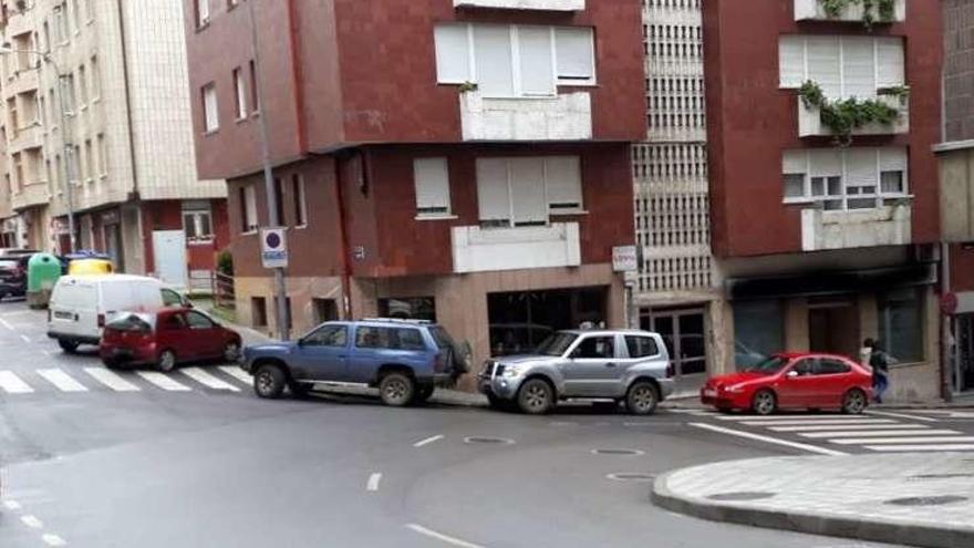 Coches aparcados en los pasos de peatones y en un carril de circulación en la avenida del Acebo.