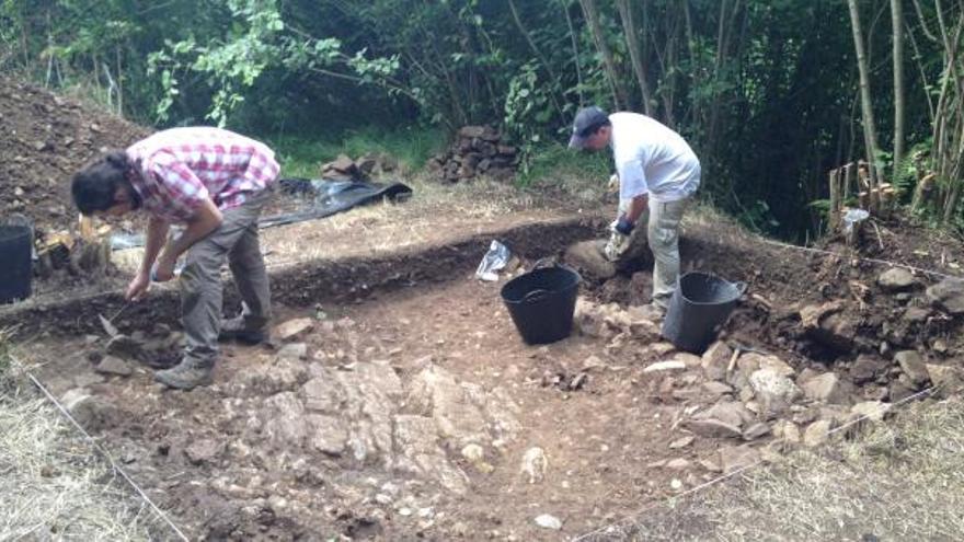 Andrés Menéndez, a la izquierda, y Jesús Rodríguez trabajando, ayer, en la cata del castro.