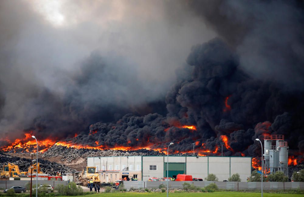 A fire rages at a tyre dump near a residential ...