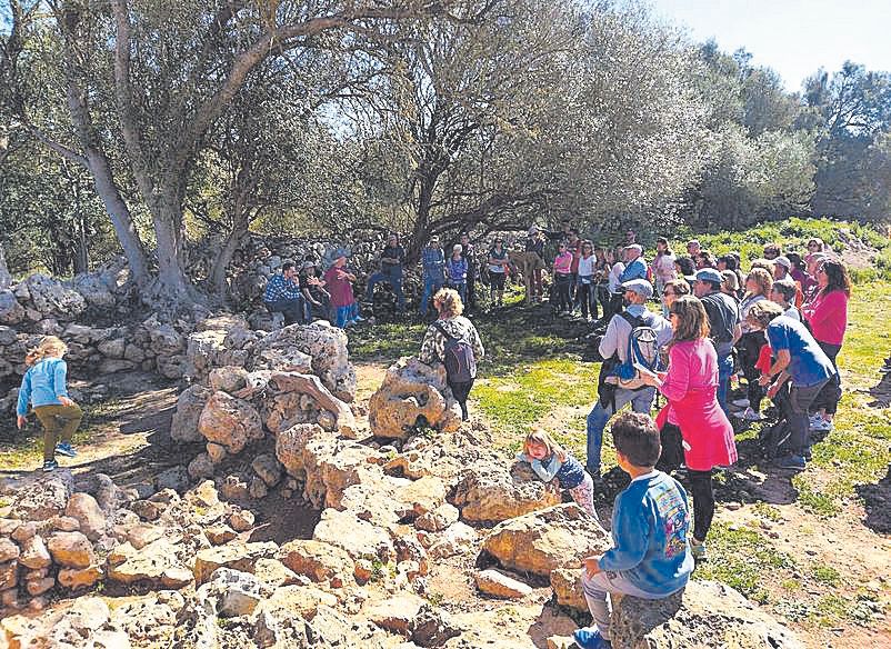 Visitantes atienden las explicaciones en el Talaiot de Can Xim (Sencelles).