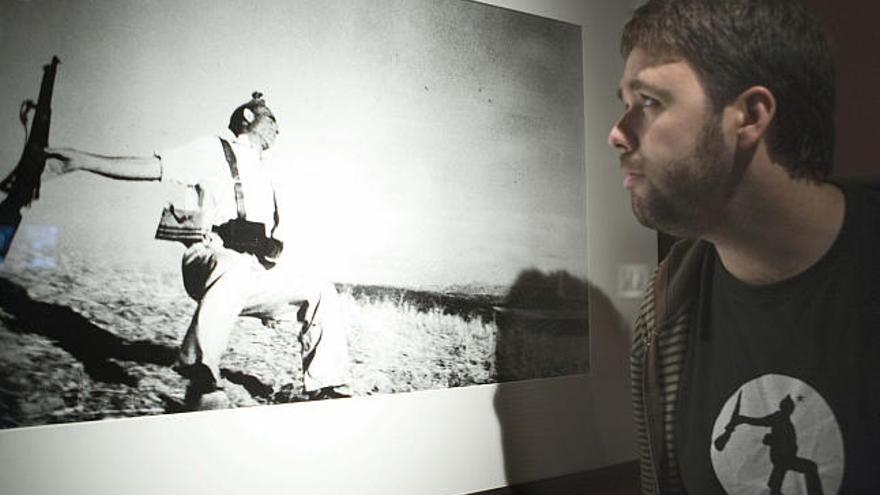 Un visitante observa la foto de la muerte de un milicano republicano en Cerro Muriano durante la Guerra Civil, una de las imágenes que integran la exposición de la obra del fotógrafo Robert Capa que se inaugura hoy en Vitoria.