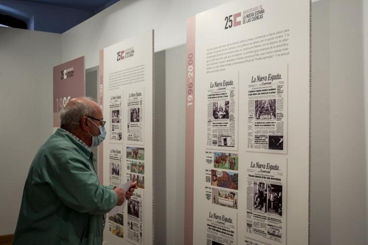 A la izquierda, Cipriano Rodríguez lee una de las tiras cómicas en la exposición de LA NUEVA ESPAÑA de las Cuencas. Debajo, Carlos Cuevas mira el cartel anunciador de la muestra. | Nazaret Quintas. | NAZARET QUINTAS