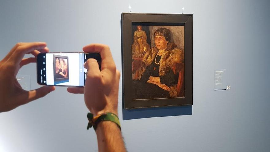 Un periodista capta con su móvil uno de los retratos de Anna Ajmátova durante la presentación a los medios.