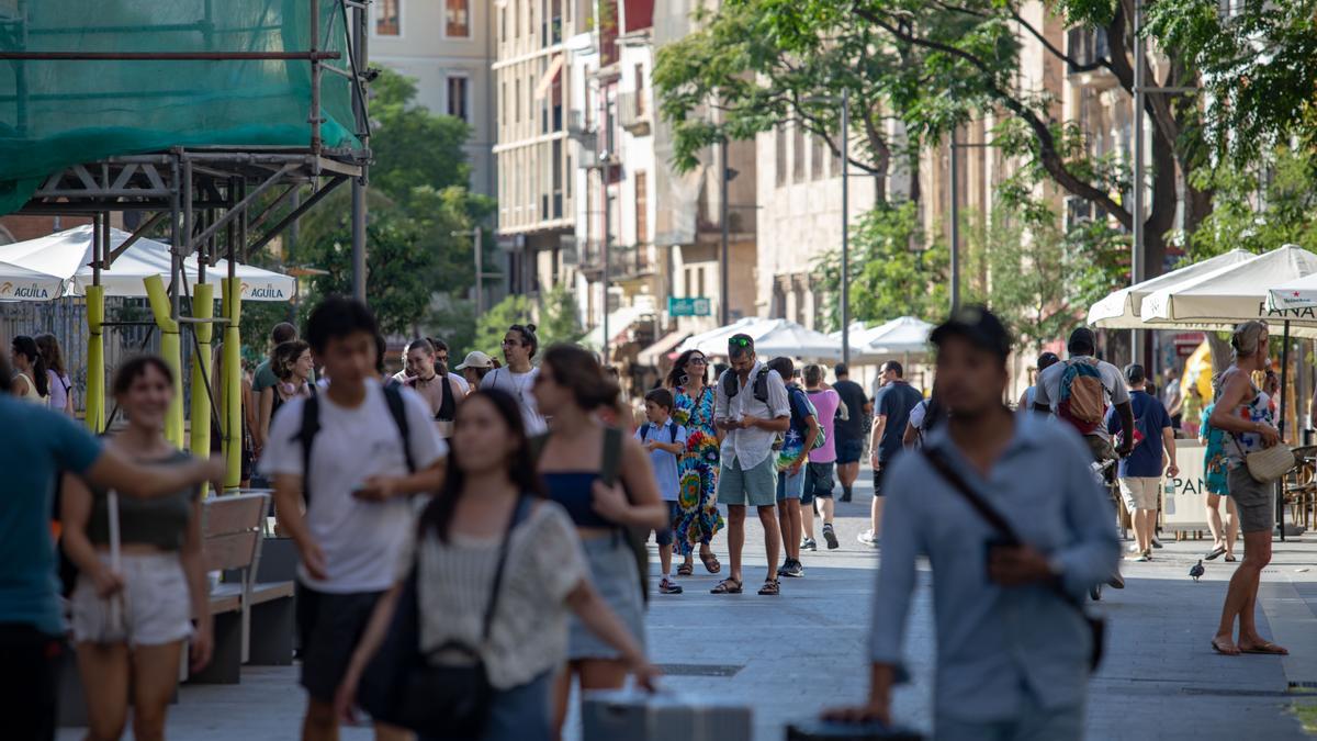 Los turistas internacionales caminan por el centro de València.