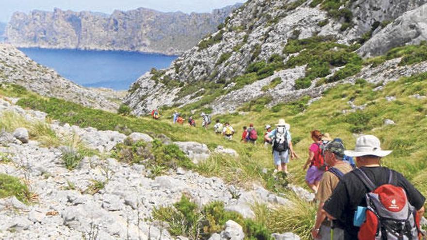 Un grupo de excursionistas recorre un camino por la zona de Cala Sant Vicenç.