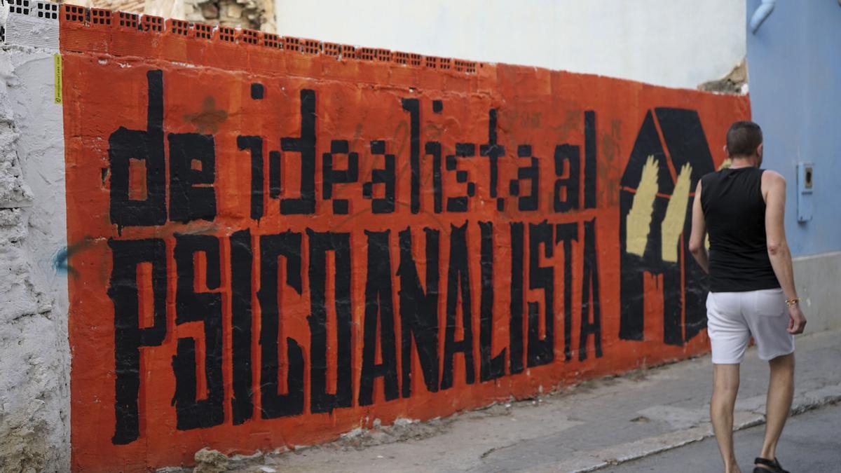 Un hombre pasa junto a uno de los grafitis en el barrio malagueño de Lagunillas, conocido por su arte urbano y su carácter obrero, pero teme desaparecer por la turistificación y el éxodo forzado de sus vecinos, quienes con esfuerzo luchan para mantener sus viviendas y la esencia del vecindario.