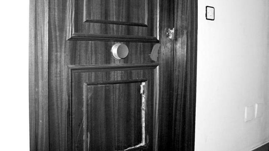 Imagen de la puerta del domicilio de la denunciada, con varios desperfectos claramente visibles.