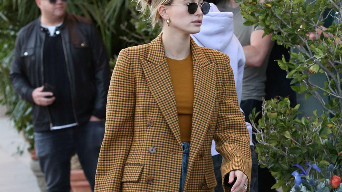 Detalle de la blazer con estampado de cuadros y corte recto que ha llevado Hailey Bieber con unos top a juego, unos jeans  y unas sandalias de tacón