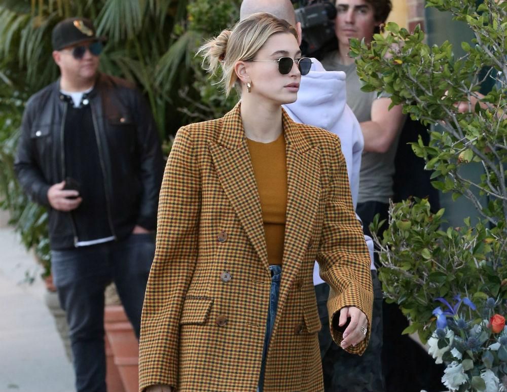 Detalle de la blazer con estampado de cuadros y corte recto que ha llevado Hailey Bieber con unos top a juego, unos jeans y unas sandalias de tacón