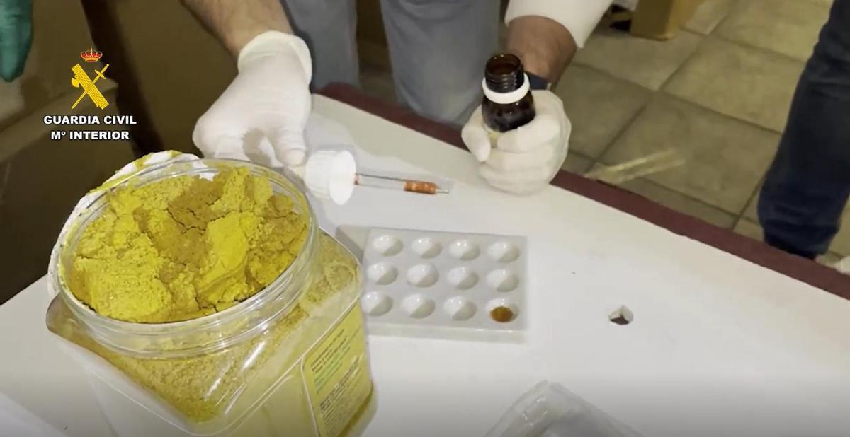 Un agente de la Guardia Civil obtiene muestras de un bote de cúrcuma.