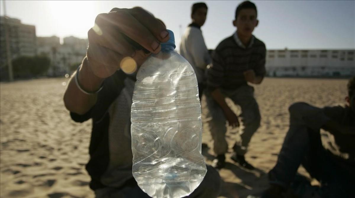 Niños de la calle, con una botella para inhalar pegamento, en una playa de Tánger.