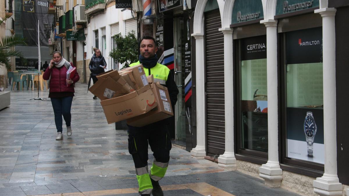 Un operario de la empresa municipal de limpieza durante la recogida puerta a puerta del cartón comercial.