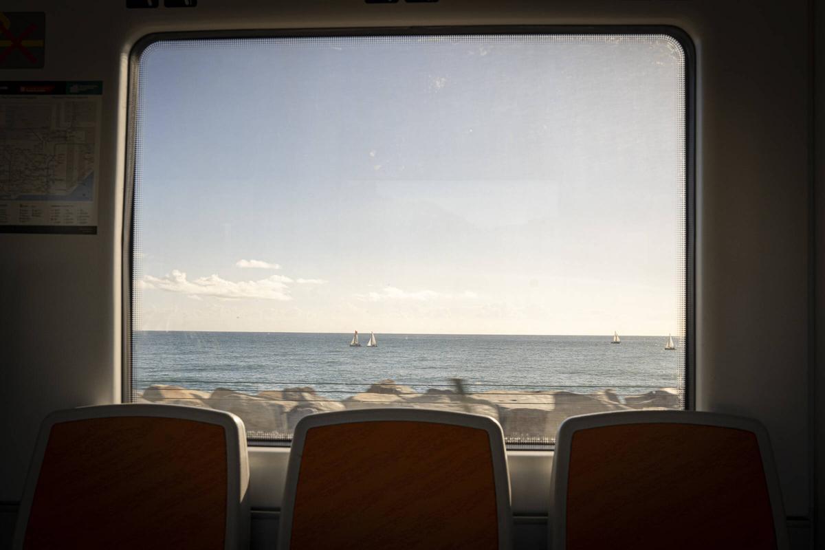 Un tren de Rodalies circula por la línea R1 del Maresme, que discurre junto al mar.
