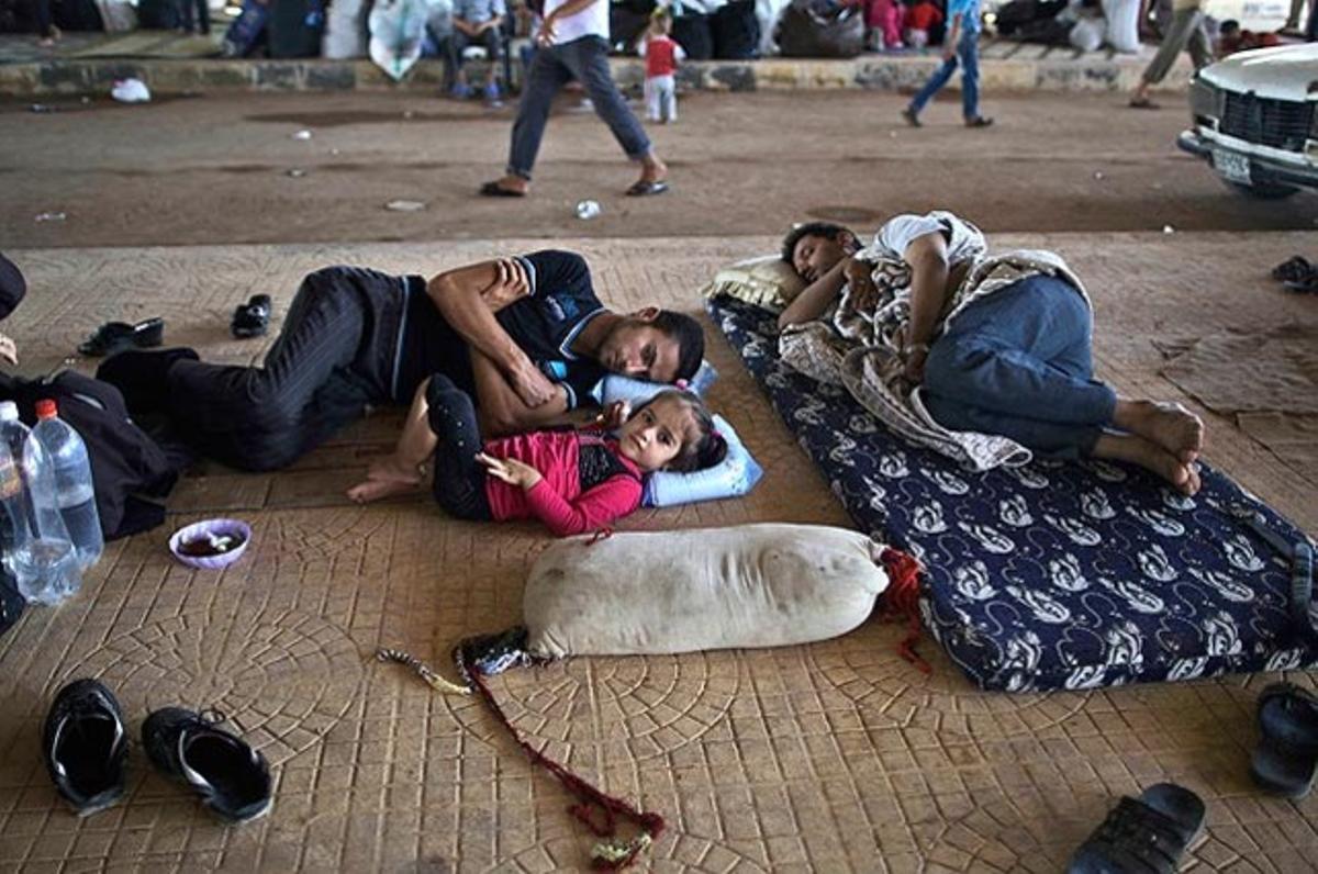 Una nena siriana, que fuig de casa amb la seva família pels enfrontaments entre l’exèrcit i els rebels, jeu a terra amb el seu pare a la frontera de Bab al-Salameh, amb l’esperança d’entrar en algun dels camps de refugiats de Turquia. Milers de sirians desplaçats pel conflicte armat tracten de refugiar-se mentre continua el pols entre govern i forces rebels.